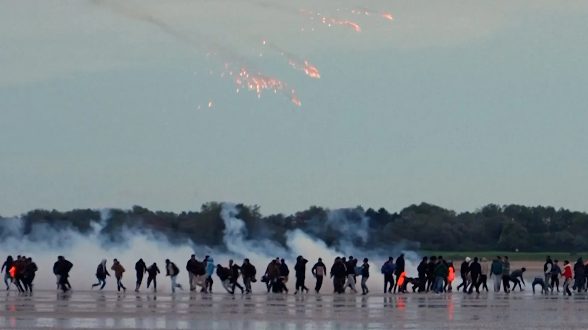 French police fire tear gas at migrants on beach